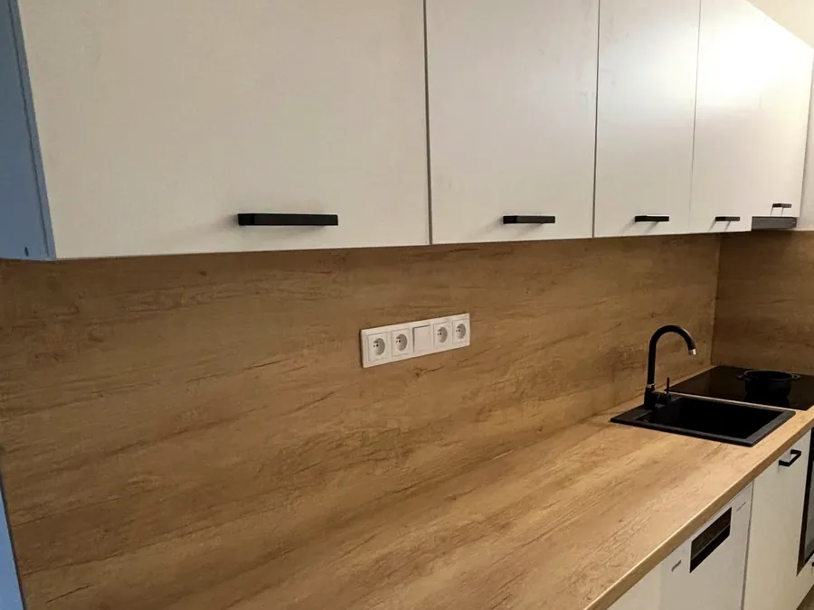 Bílá kuchyňská linka s dubovou deskou a dřezem